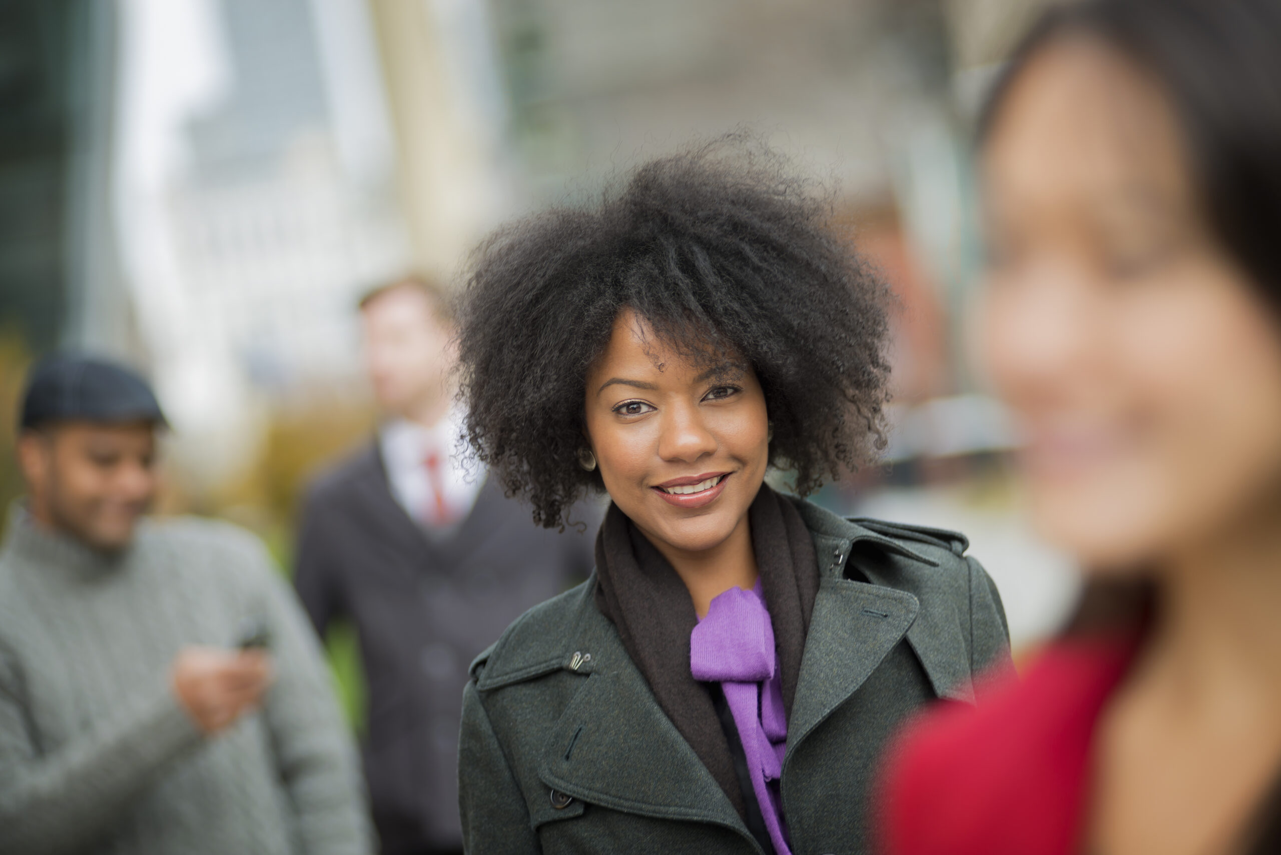 City life. A group of people on the go, keeping in contact, using mobile phones, and talking to each other. Men and women.